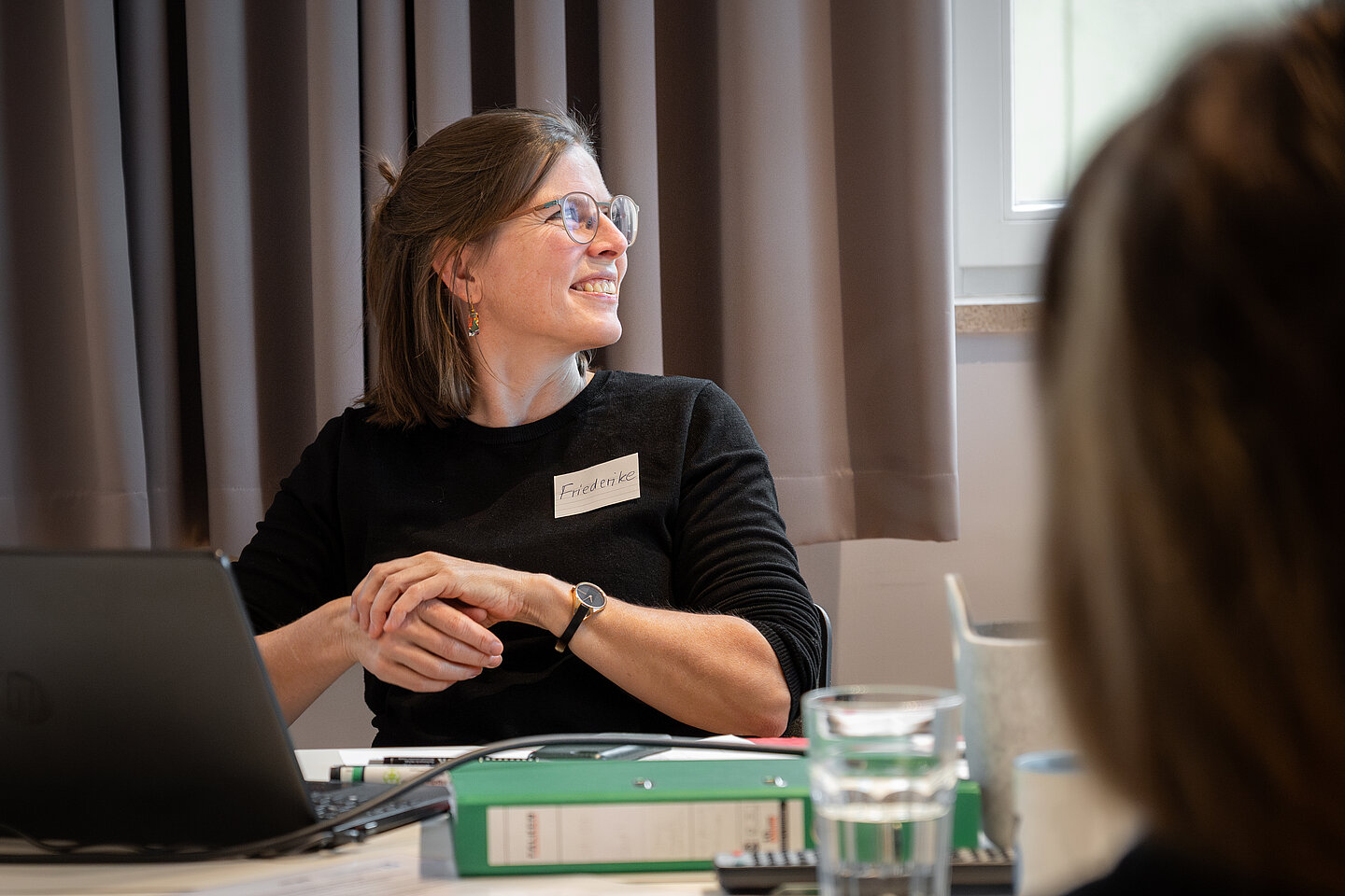 Dr. Friederike Frieler eine Frau sitzt am Tisch und lacht