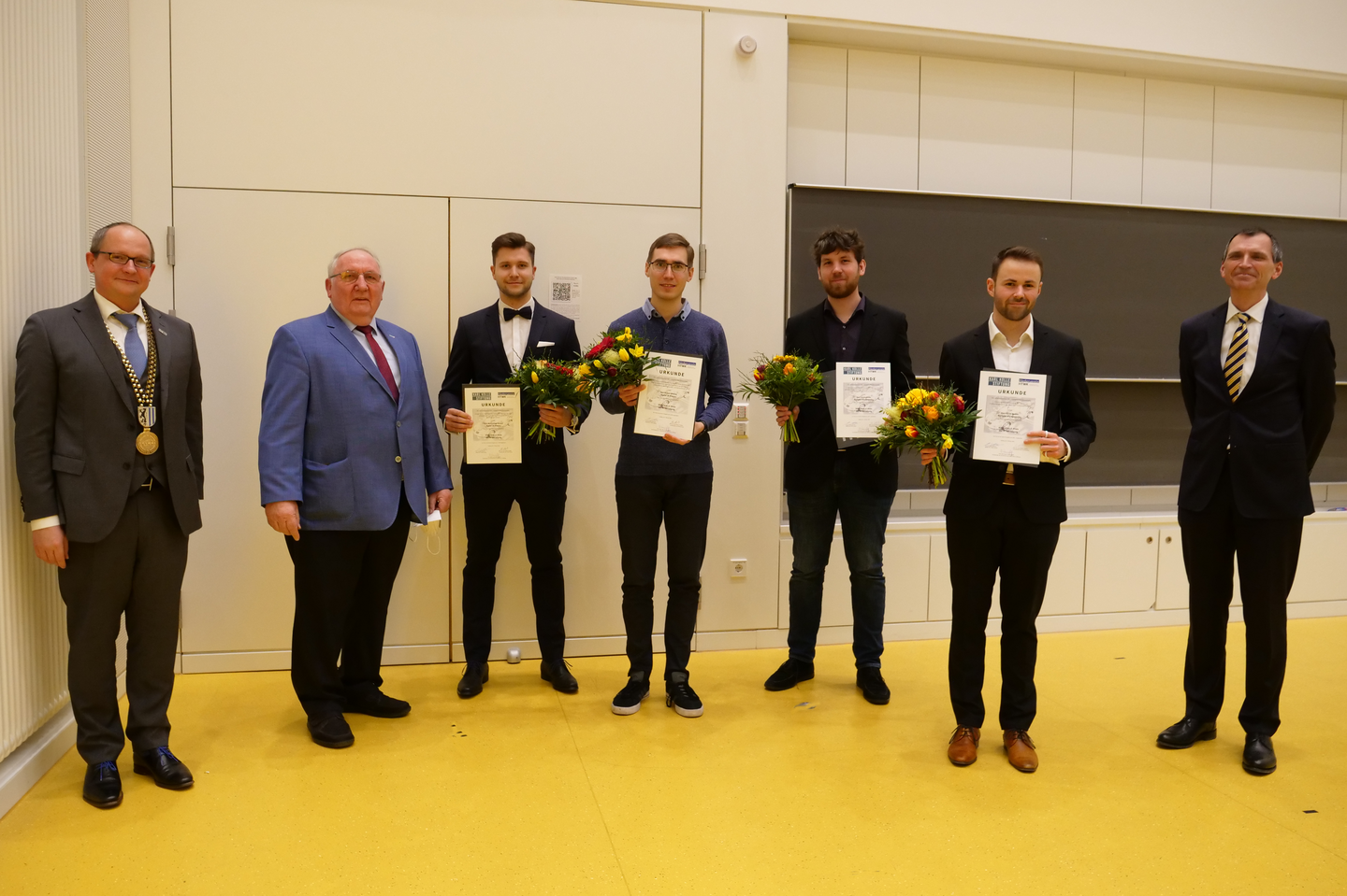 Gruppenfoto, alle mit Masken und Urkunden
