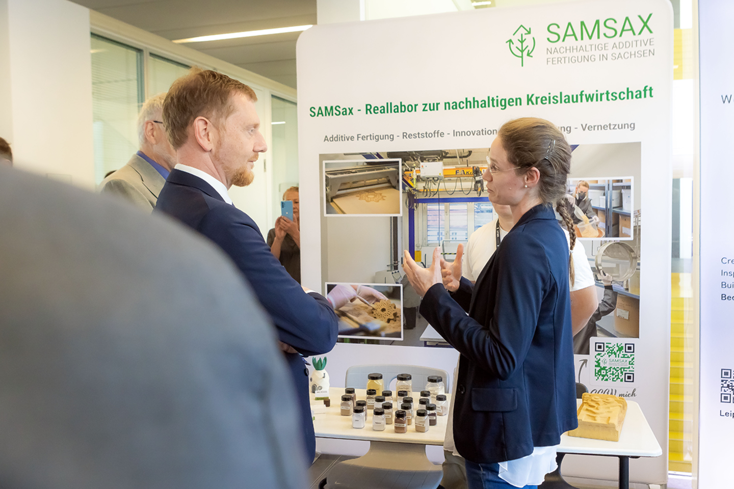 Ministerpräsident Michael Kretschmer informiert sich am SamSax Stand bei Lisa Kühnel über 3D-Druck Projekt