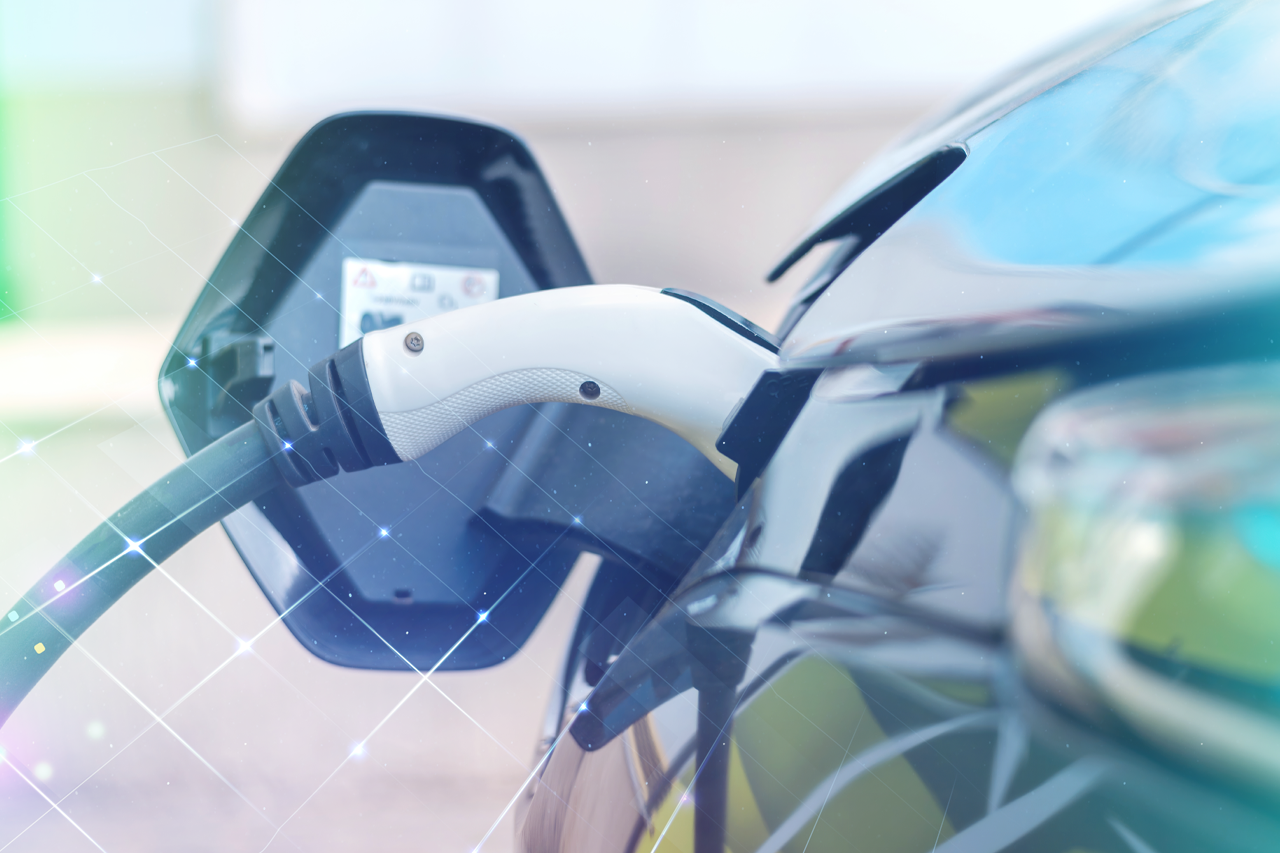 Nahaufnahme eines elektrischen Autos und des Ladekabels/Verlinkung führt zur Projektwebsite